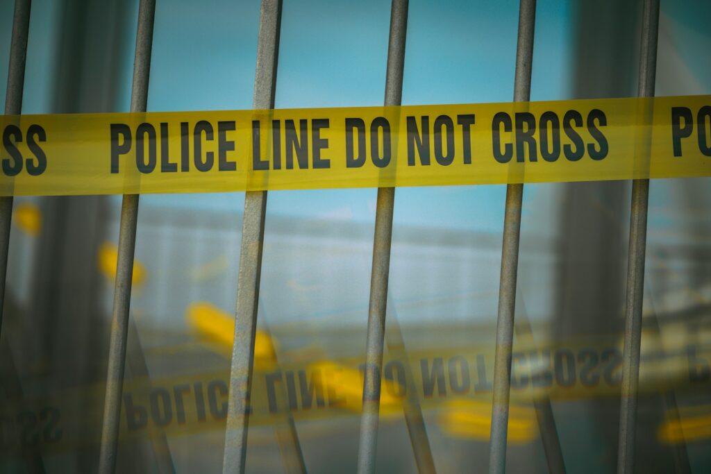 a close up of a yellow police line behind bars