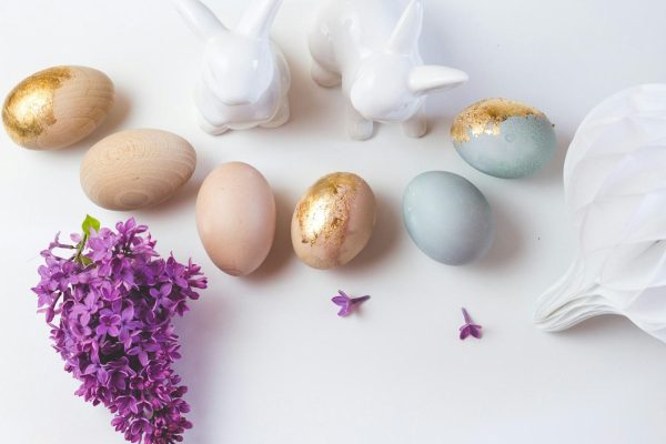 white ceramic rabbit figurine beside purple flowers
